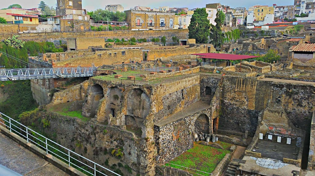 Herculaneum, photo taken between October 2014 and November 2019. Photo courtesy of Giuseppe Ciaramella.
The access footbridge, on the left, leads onto the roadway Cardo III. 
In the centre is the Casa dell’Albergo with its portico and rooms below it. On the right is the Sacred Area.